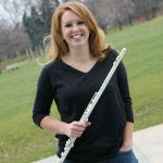 Heather dressed in black holding a silver flute.